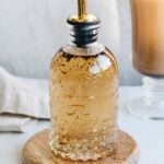 vanilla bean syrup in a glass bottle with a gold spout