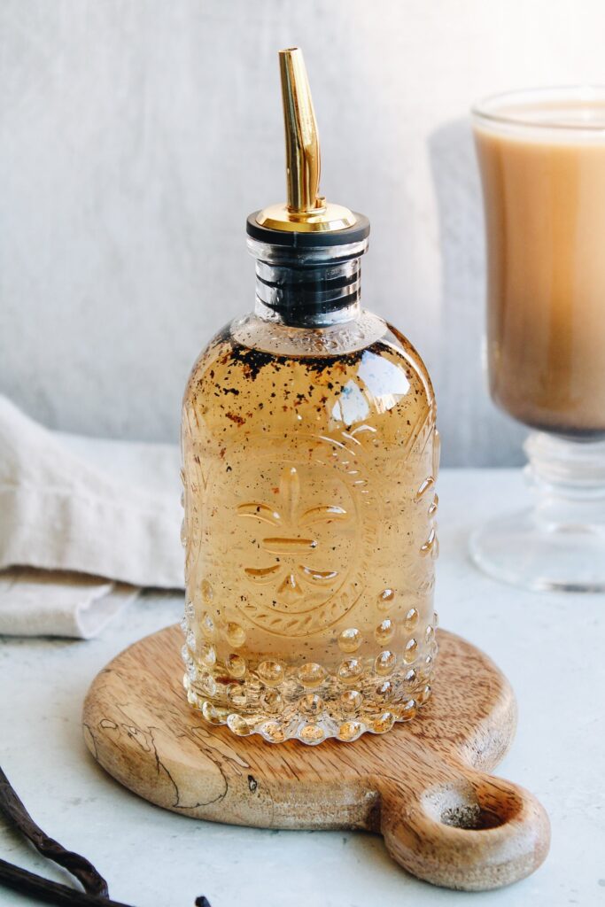 vanilla bean syrup in a glass bottle with a gold spout