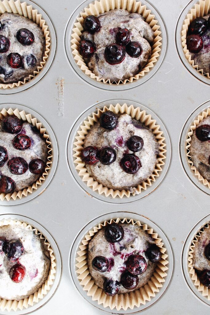 muffin tin filled with blueberry buckwheat muffin batter
