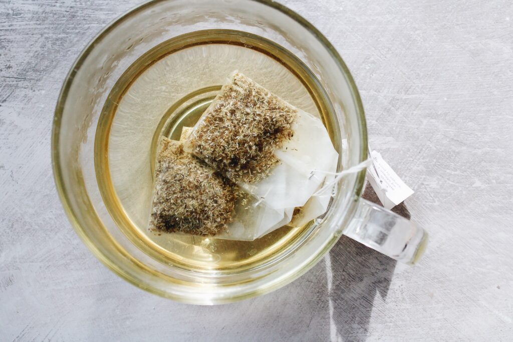 four chamomile tea bags steeping in hot water