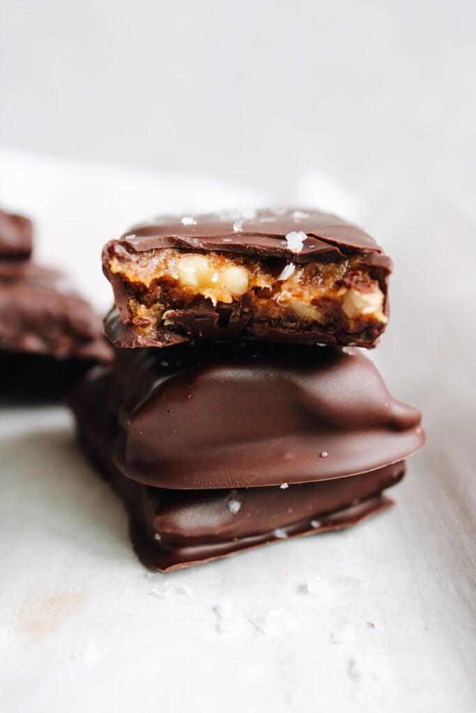 chocolate date bars stacked on a piece of parchment