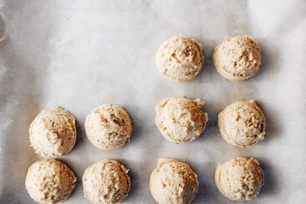 cookie dough balls on a baking sheet lined with parchment, ready to freeze!