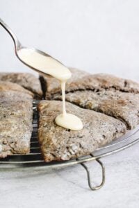 maple glaze being drizzled onto a buckwheat scone