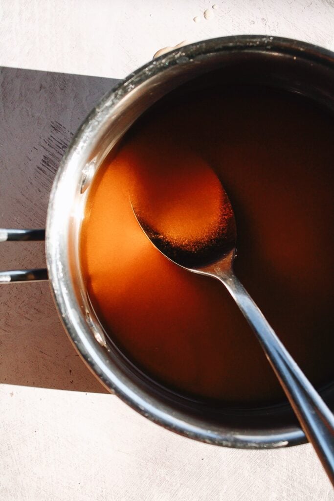 Tea and sugar being stirred in a pot