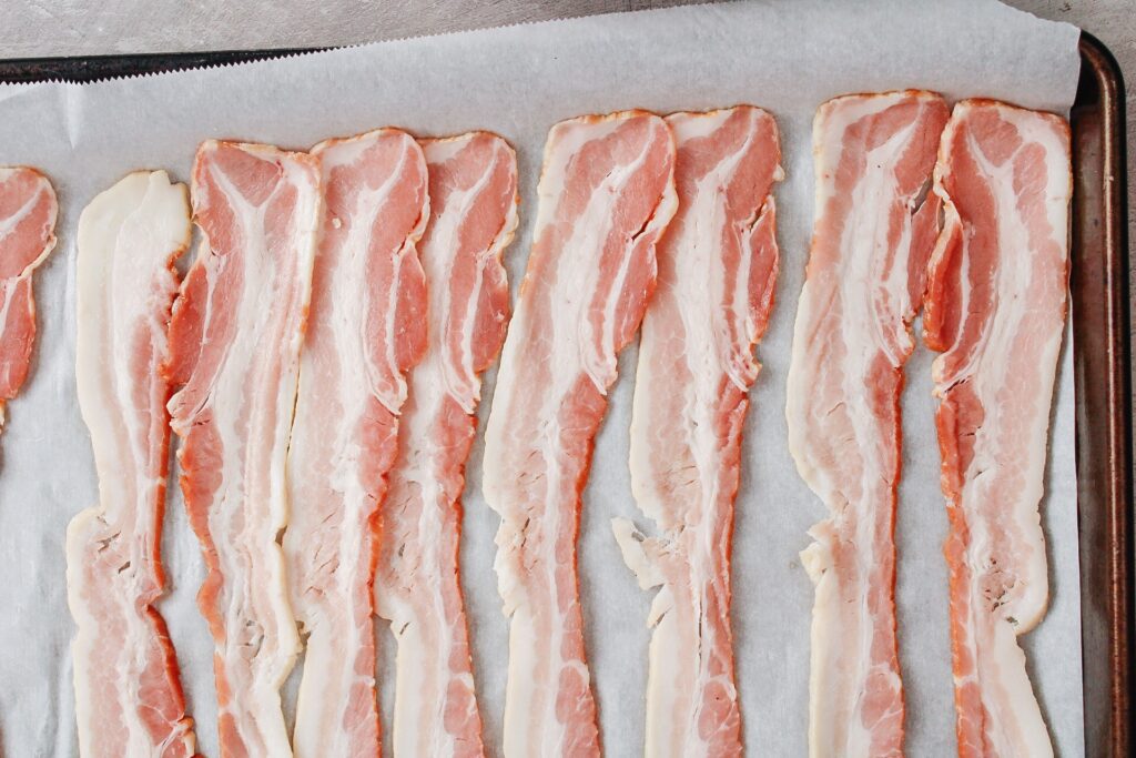 bacon strips on a baking sheet lined with parchment