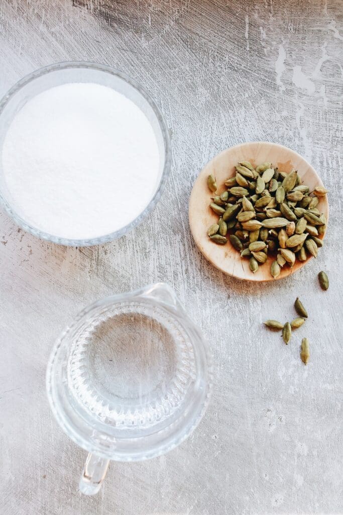 ingredients for cardamom syrup on a gray background
