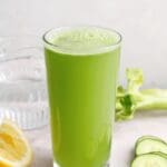 cucumber celery juice in a clear glass on a gray background