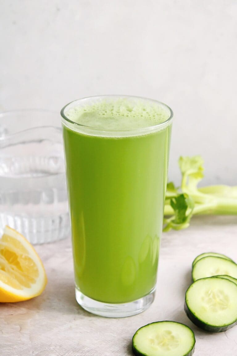 cucumber celery juice in a clear glass on a gray background