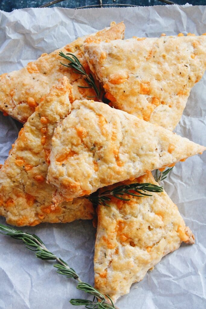 cheddar rosemary scones on white parchment paper
