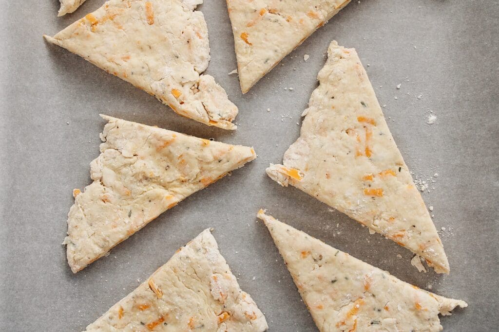 rosemary cheddar scones on a baking tray with parchment