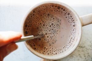 lavender hot chocolate being whisked with a mini whisk