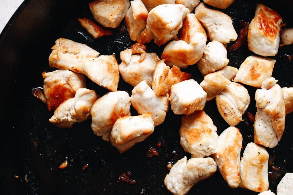 cooked chicken breast pieces in a cast-iron skillet