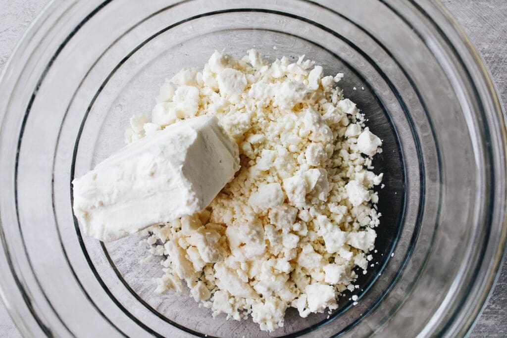 cream cheese and feta cheese in a mixing bowl