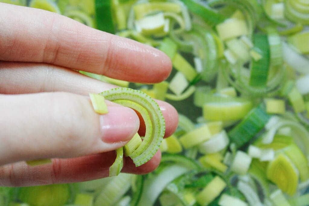 close up image of leeks in someones fingers