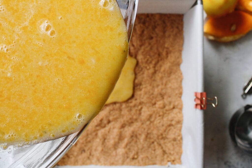 lemon square filling poured onto hot graham cracker crust