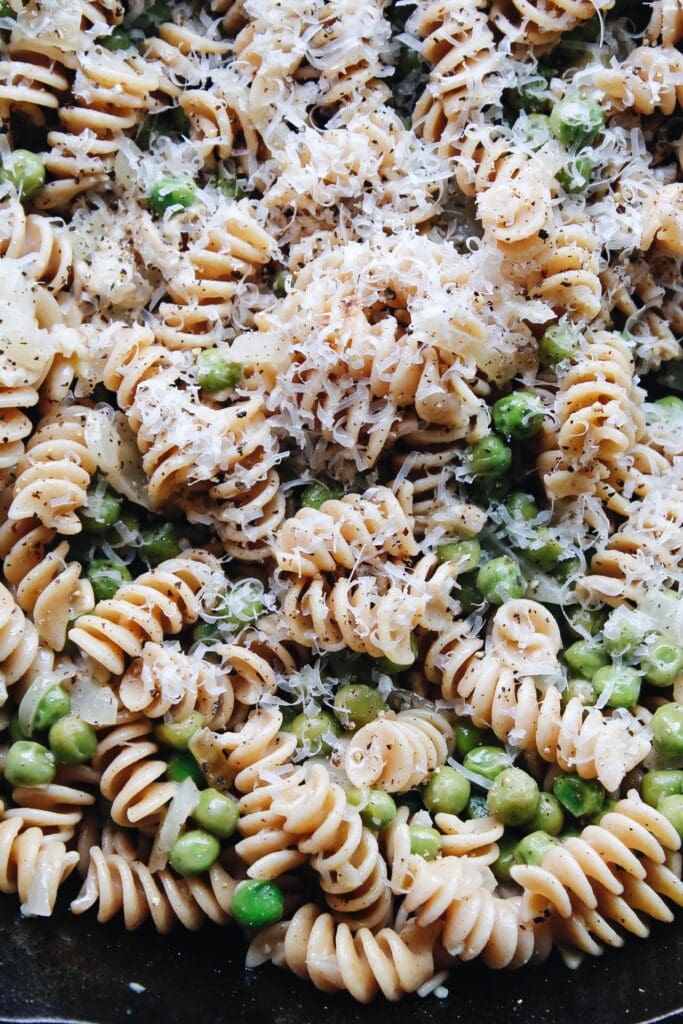 close up photo of pasta with peas in a cast-iron skillet