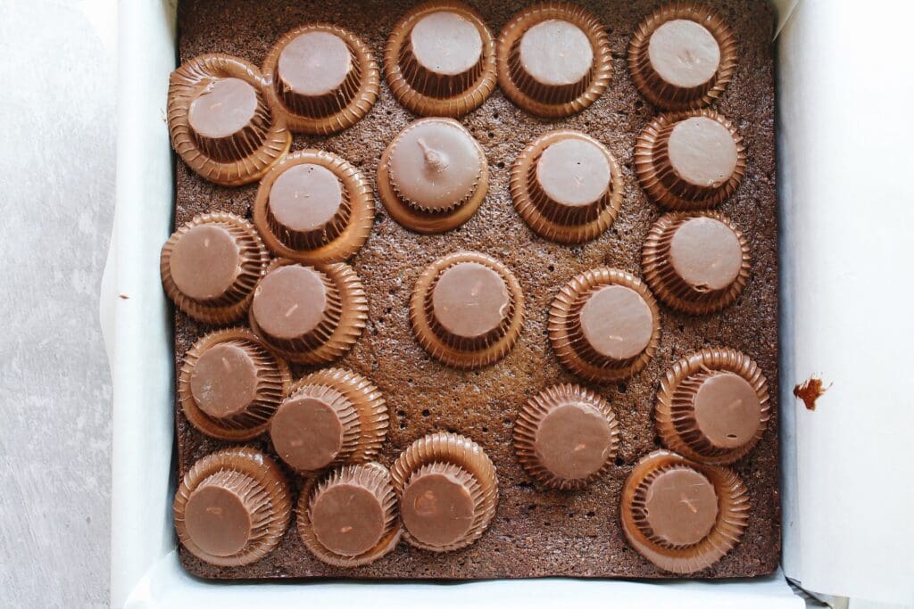 peanut butter cups melting on top of brownies right out of the oven 