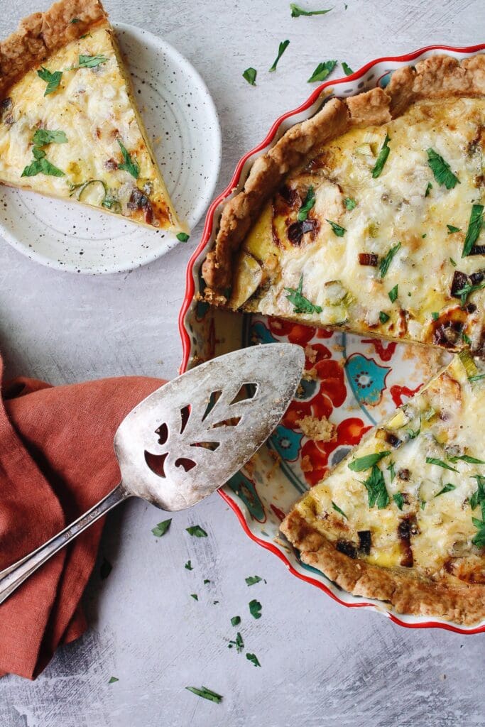 potato and leek quiche with a slice removed and on a plate