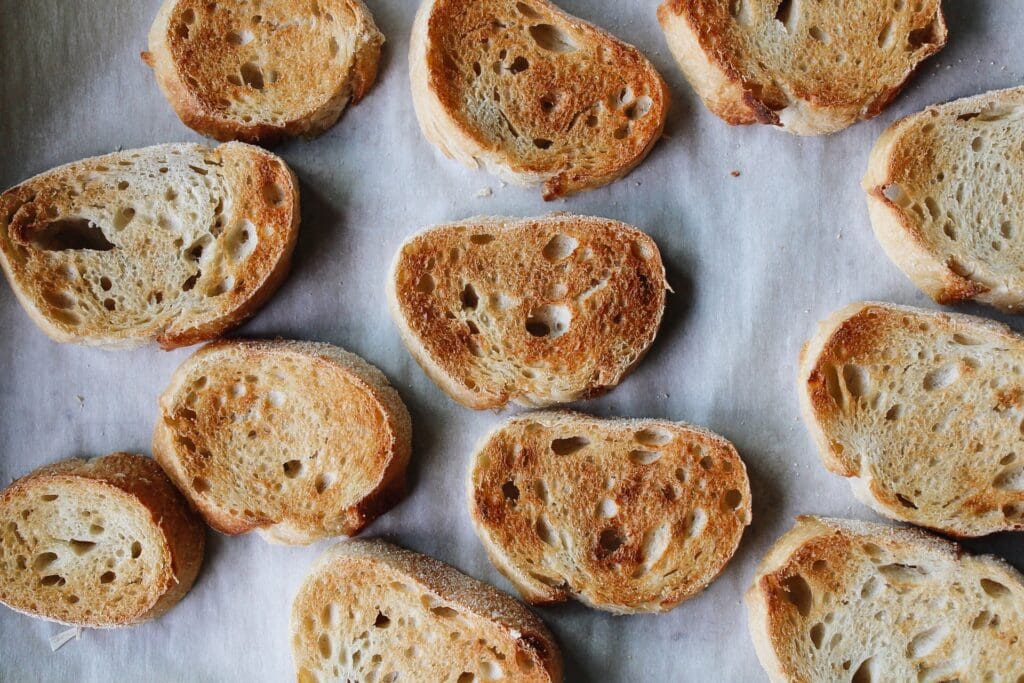 toasted slices of a baguette on a baking sheet