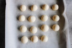 rose white chocolate balls on a baking sheet with parchment