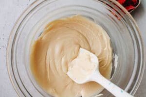 white chocolate chips, sweetened condensed milk, vanilla, salt and rose water melted in a bowl