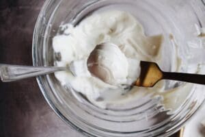 rose white chocolate truffle ball being lifted out of melted white chocolate