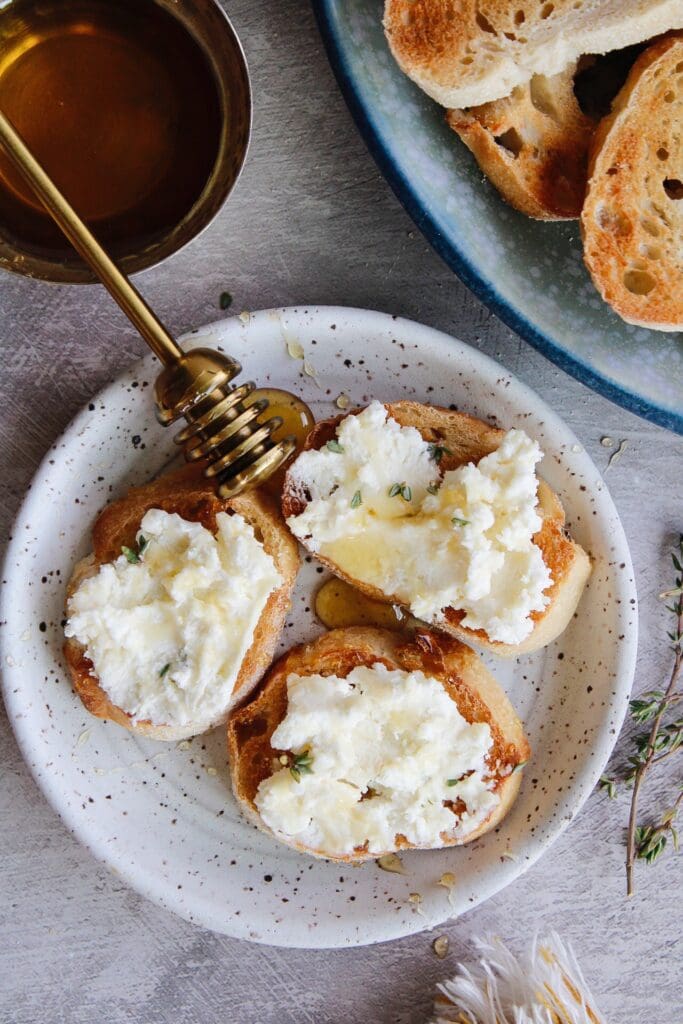 whipped feta and honey garlic toasts on a small white plate