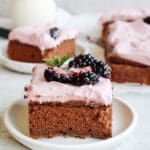 slice of blackberry chocolate cake with blackberry cream cheese frosting on a white plate