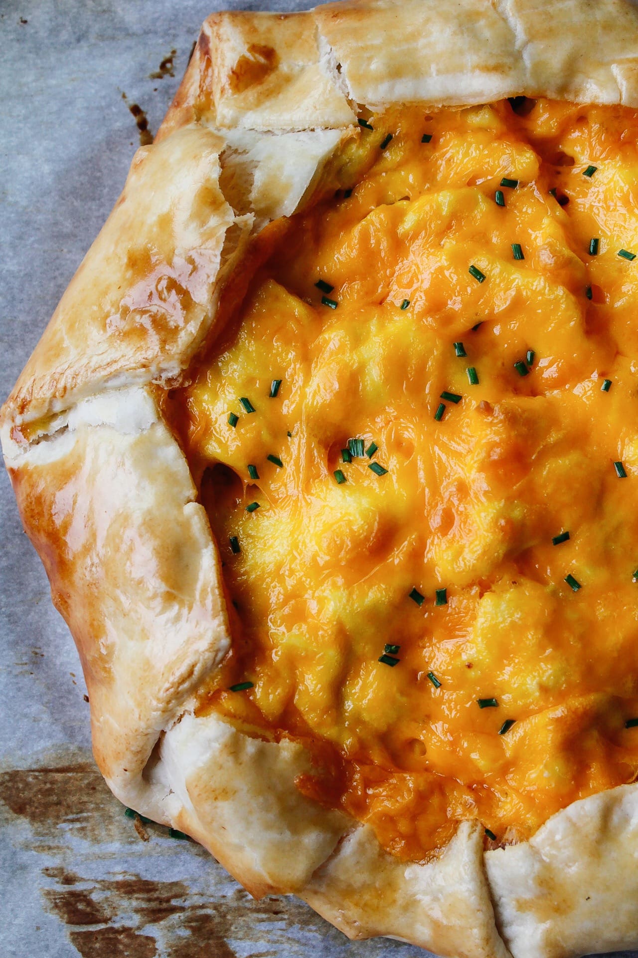 close up of breakfast galette topped with cheddar cheese and chives