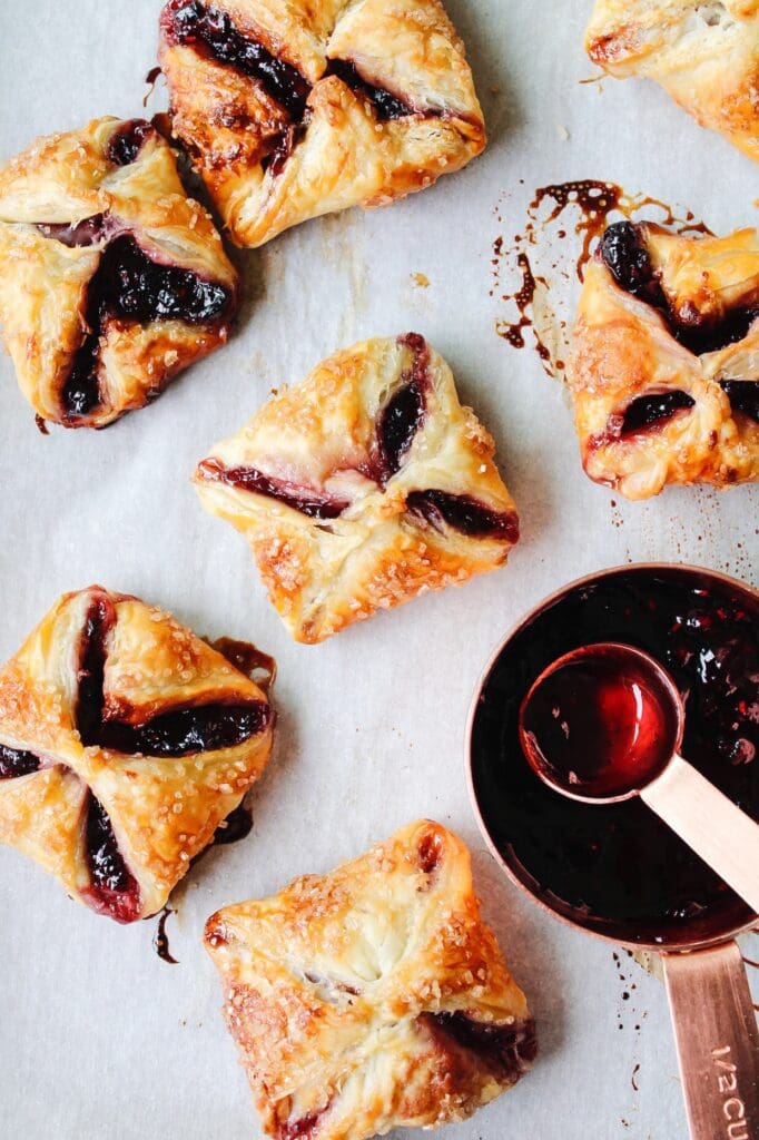 jam puff pastry tarts on a piece of parchment paper