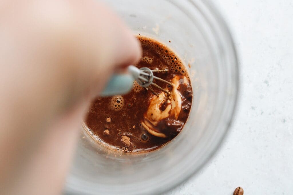 cocoa powder, sugar, vanilla, peanut butter and small amount of hot coffee being whisked