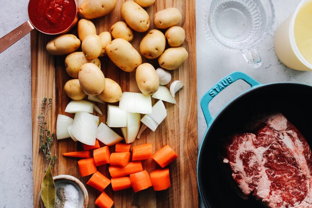 ingredients for cutch oven pot roast on a cutting board and countertop