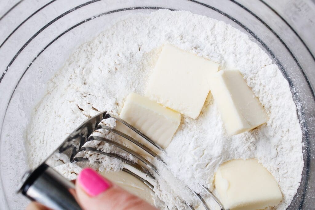 butter being cut into dry scone ingredients