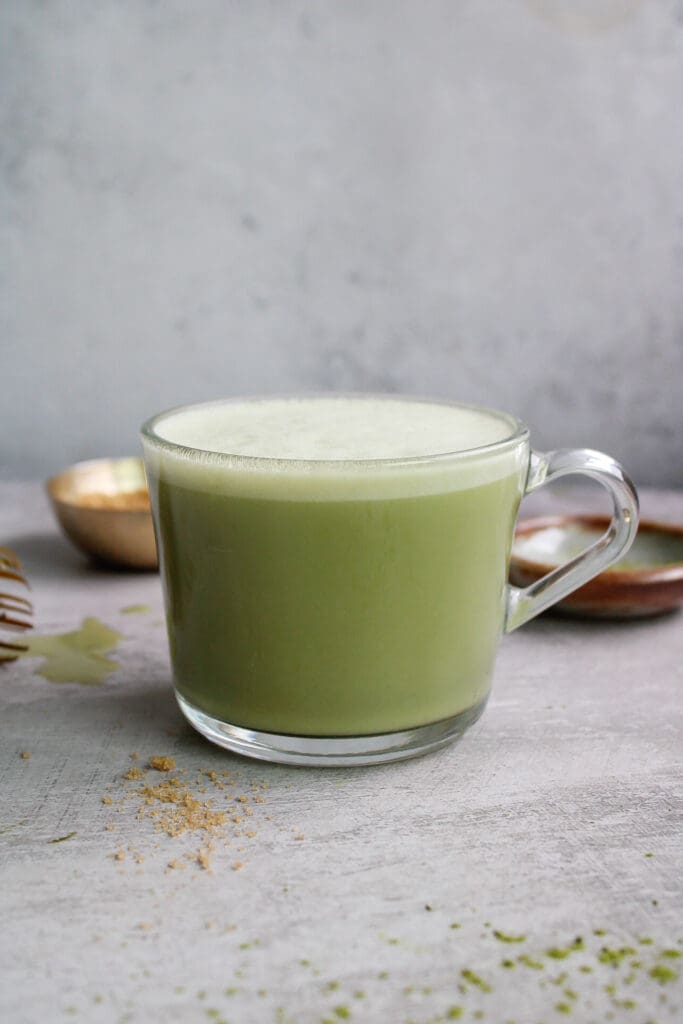 hot oat milk matcha latte in a clear mug