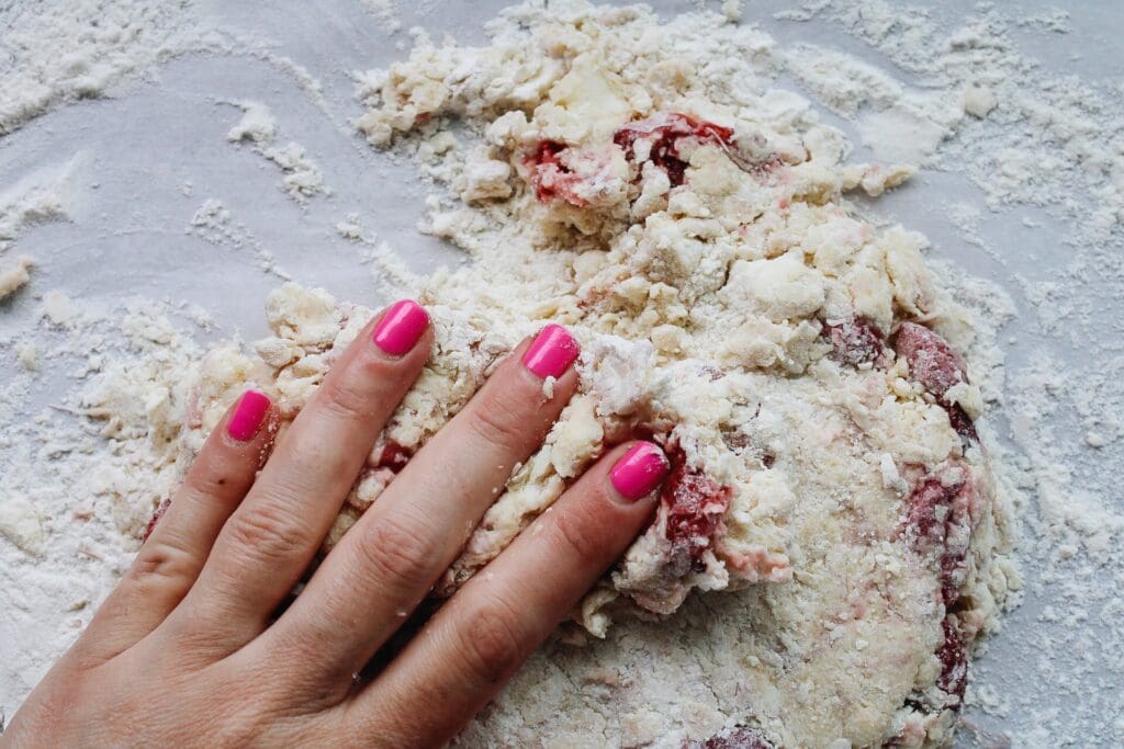 strawberry scone dough being kneaded