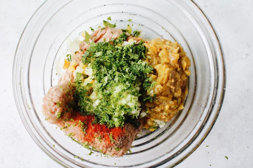 ground chicken, cilantro, green chiles, onion and spices in a mixing bowl