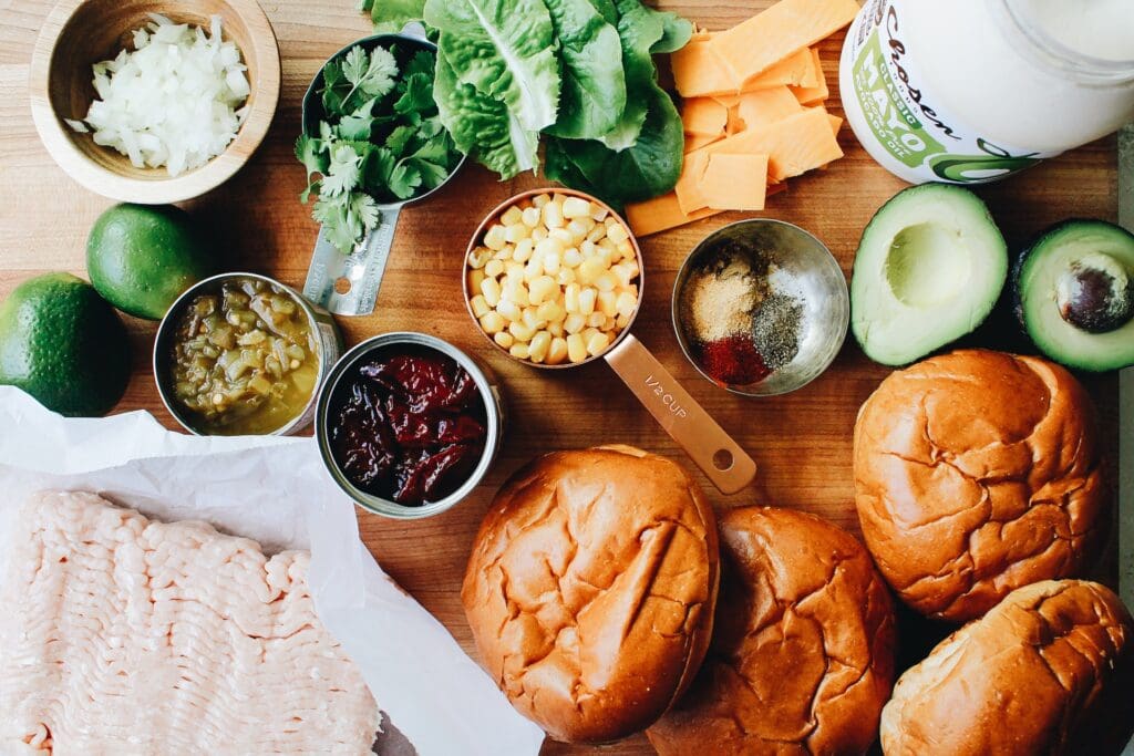 ingredients for southwest chicken burgers on a wooden board