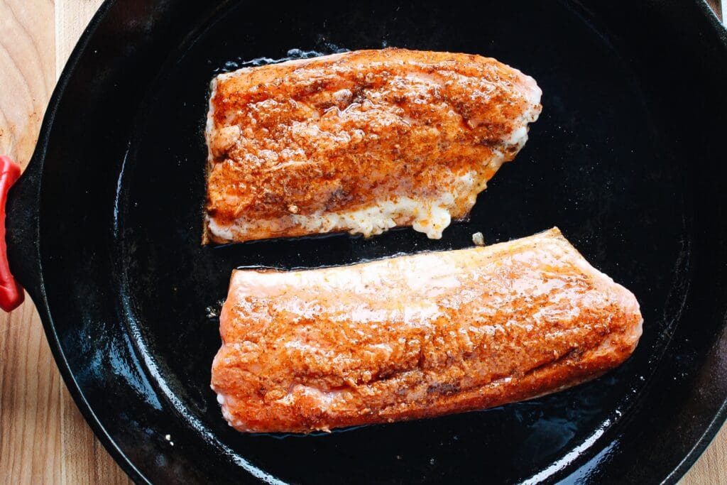 salmon cooking in a skillet