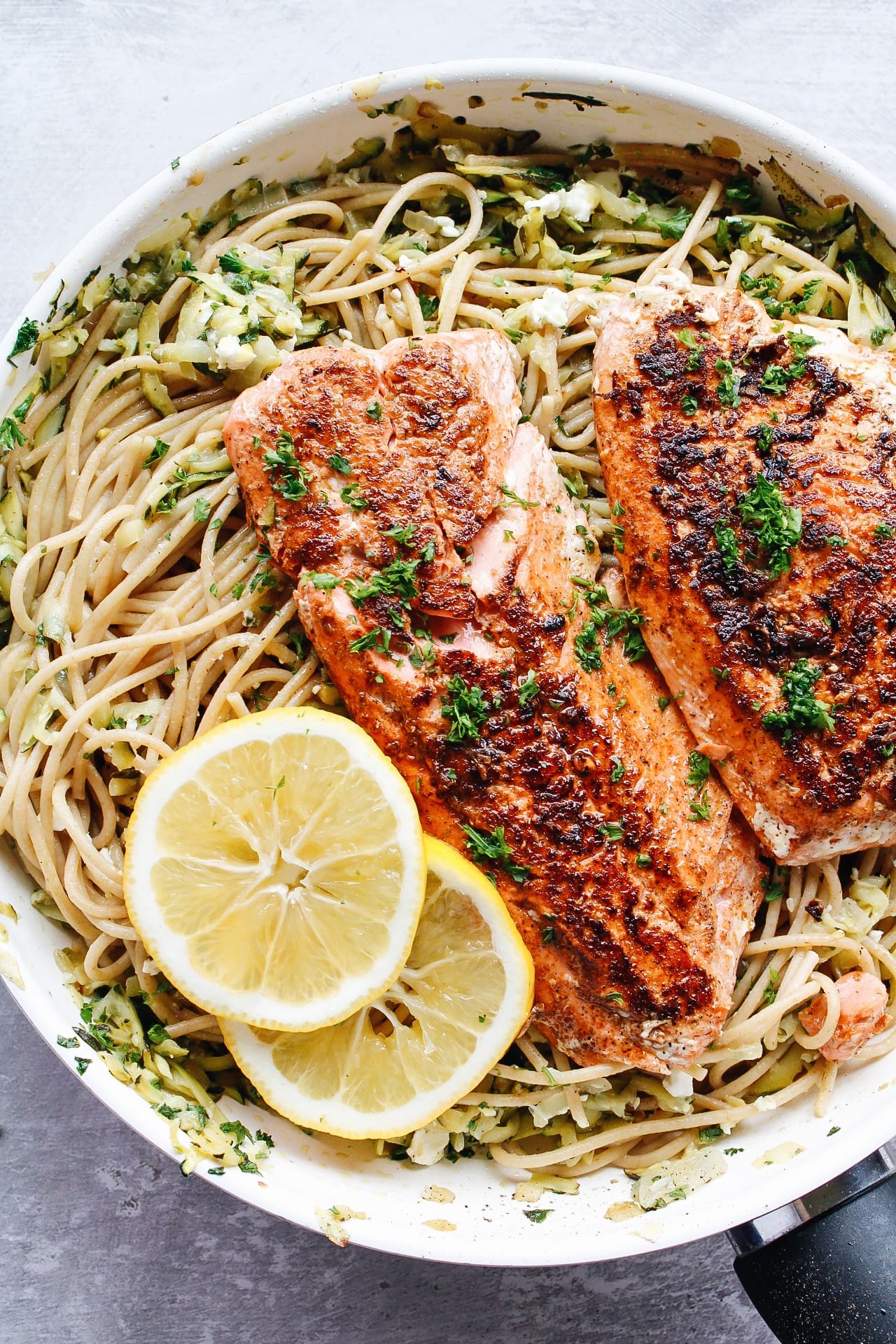 salmon pasta without cream in a skillet topped with lemon slices