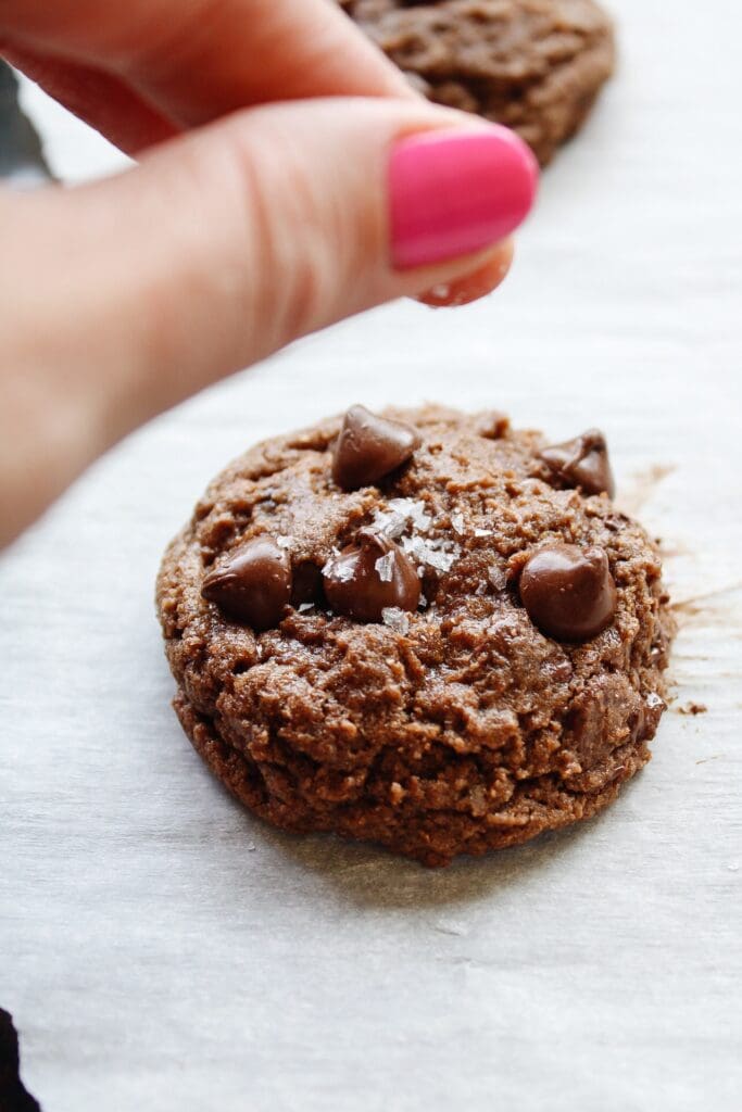 sea salt being sprinkled on top of cookie