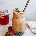 strawberry bubble tea in a mason jar with a straw and mint