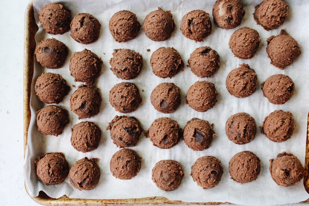cookie dough balls on a parchment lined baking sheet ready to freeze