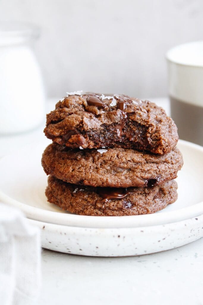 whole wheat chocolate chocolate chip cookies stacked on a white plate