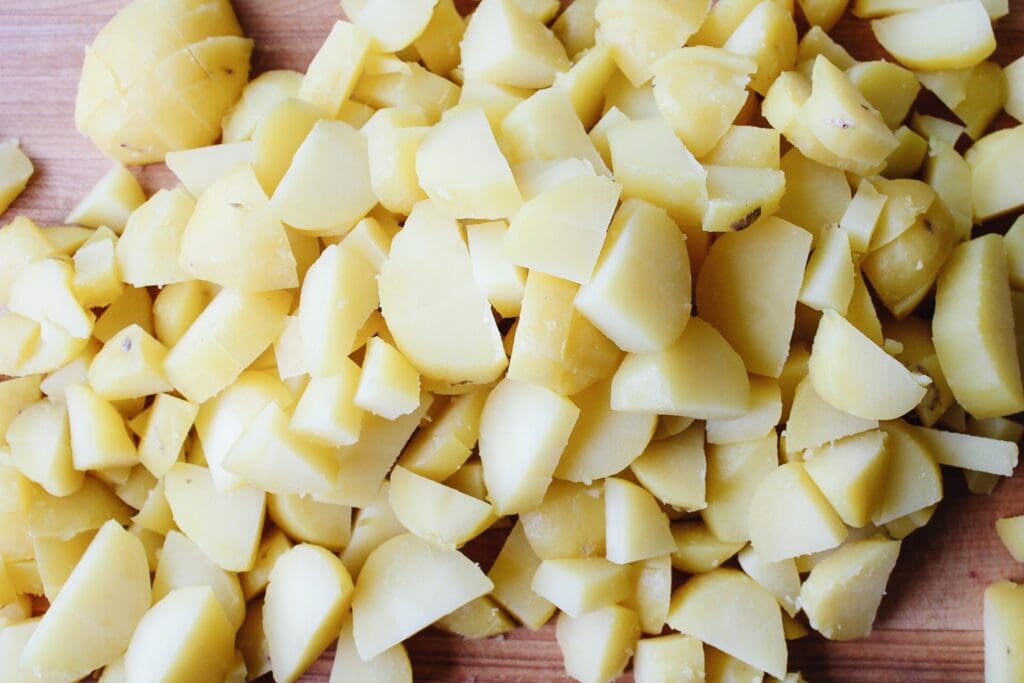peeled and chopped potatoes on a cutting board