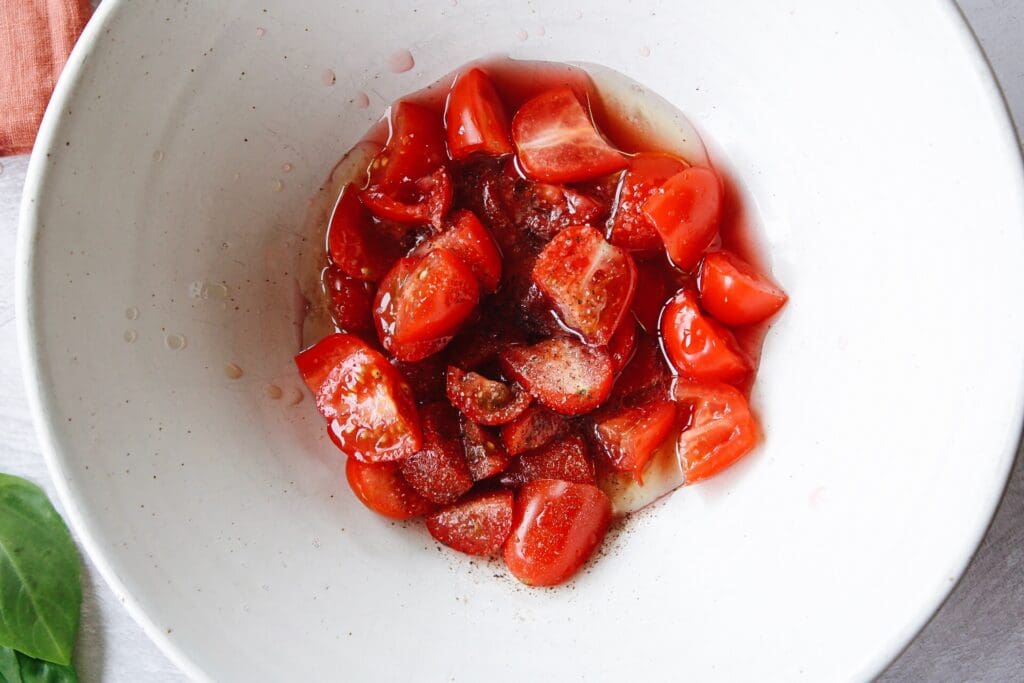 tomatoes marinating in red wine vinegar, oil, salt and pepper
