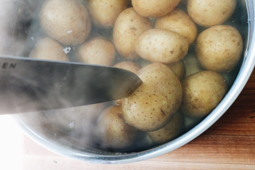 boiled potatoes being pierced with a knife