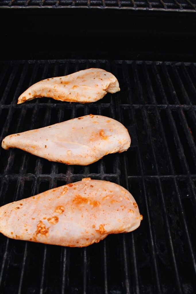 greek chicken breast just placed on the grill