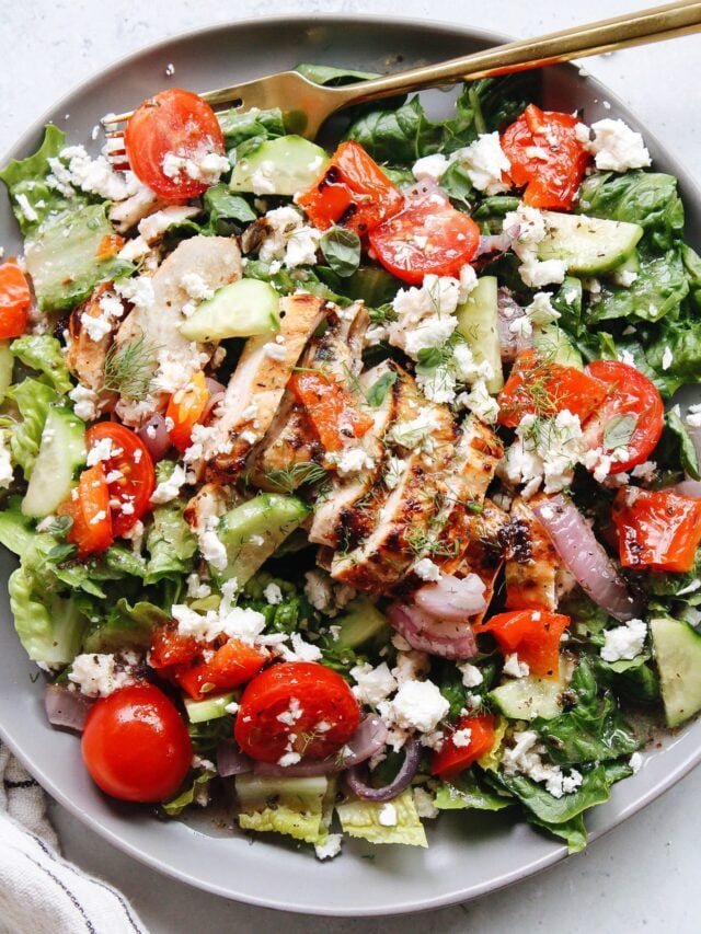 greek grilled chicken salad on a plate with a gold fork