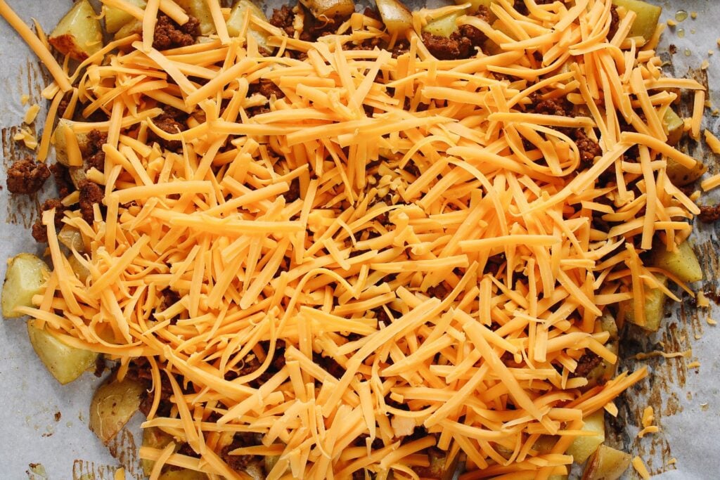 cheddar cheese topping ground beef and potatoes for potato taco bowls