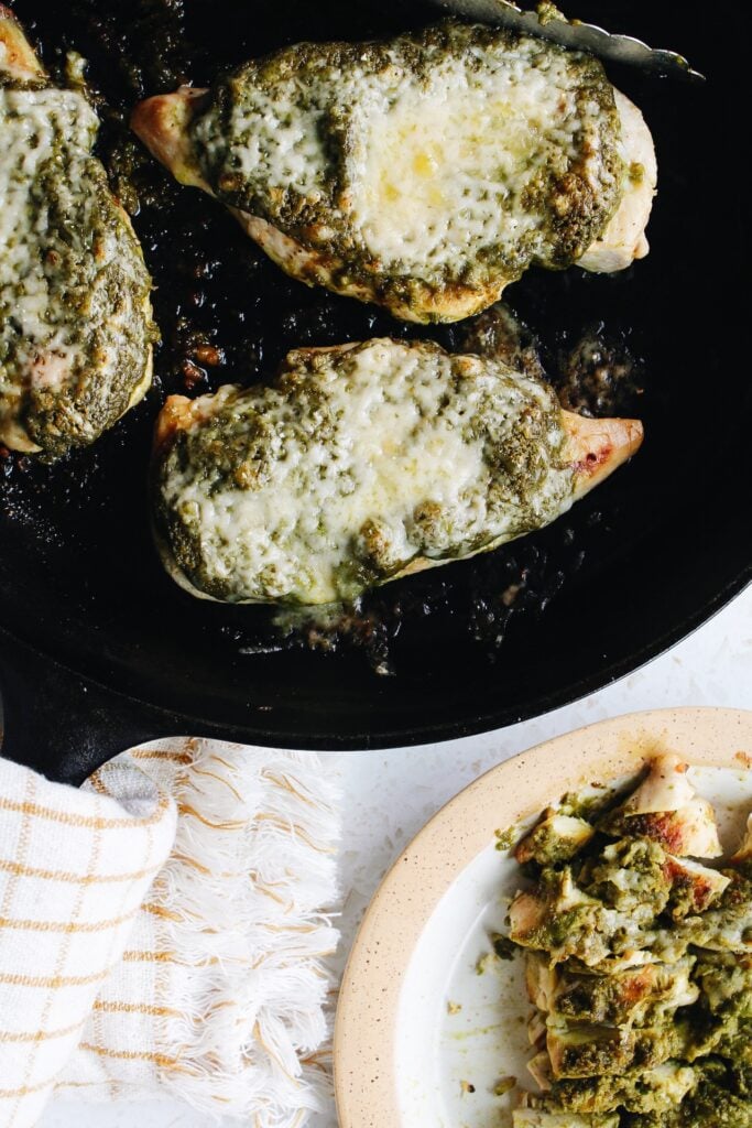 pesto baked chicken in a cast iron pan and plated